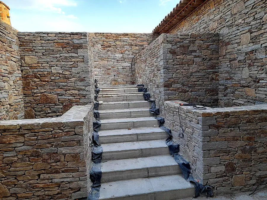 Escalier extérieur entre des murs en pierre, couvertines posées