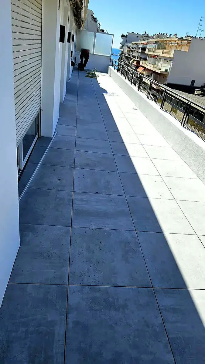 Après les travaux : la même terrasse carrelée en gris clair